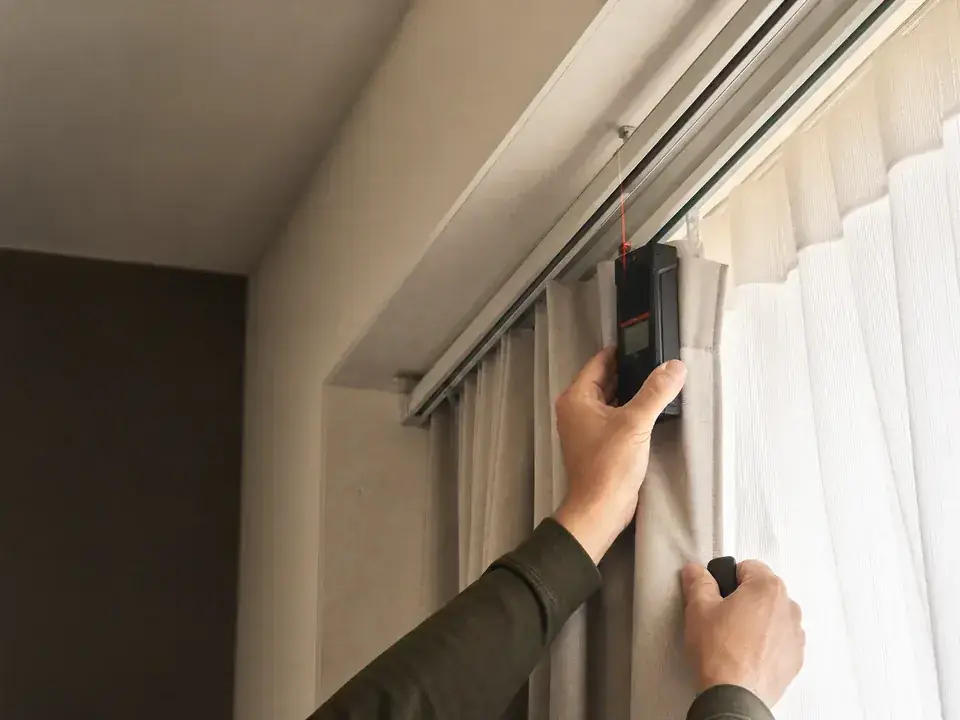 Technician assessing an existing curtain track for motorized retrofit suitability